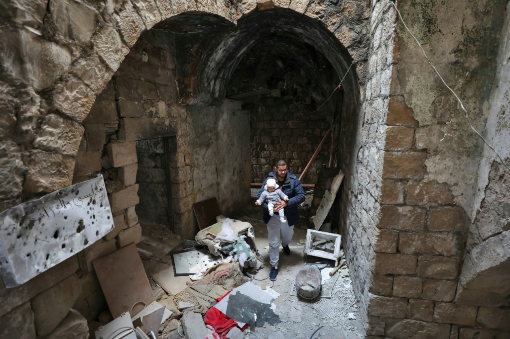  تجمع فلسطينيون لالتقاط صور بين أنقاض المنزل الذي استهدف خلال غارة إسرائيلية في نابلس بالضفة الغربية المحتلة (أ ف ب)