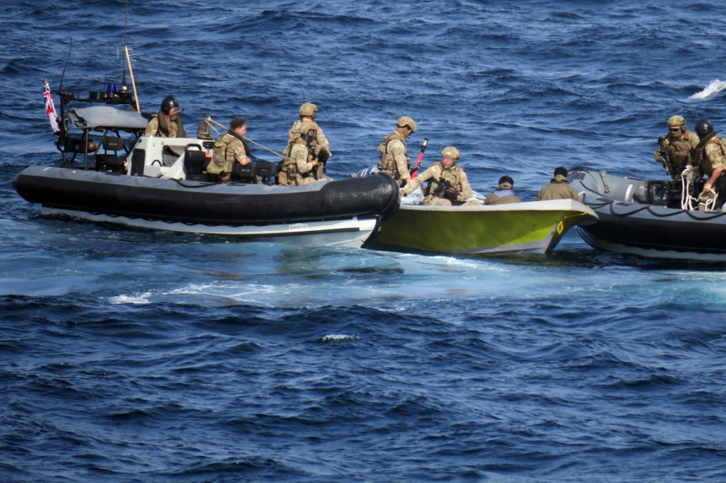 مشاة البحرية البريطانية يزيلون الأسلحة الإيرانية التي تم العثور عليها على متن قارب تهريب مشتبه به تم اعتراضه في خليج عمان في 23 فبراير (ا ف ب)