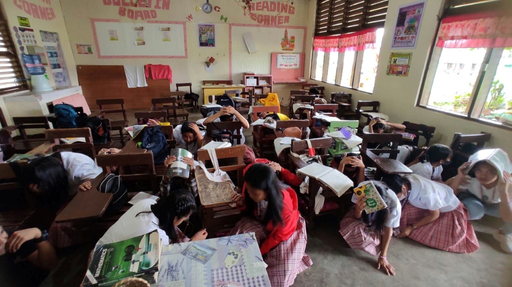تلاميذ في مدرسة بوسو الثانوية يحتمون داخل الصف بعدما ضرب زلزال بقوة ست درجات جنوب الفيليبين في السابع من آذار/مارس 2023 (ا ف ب)