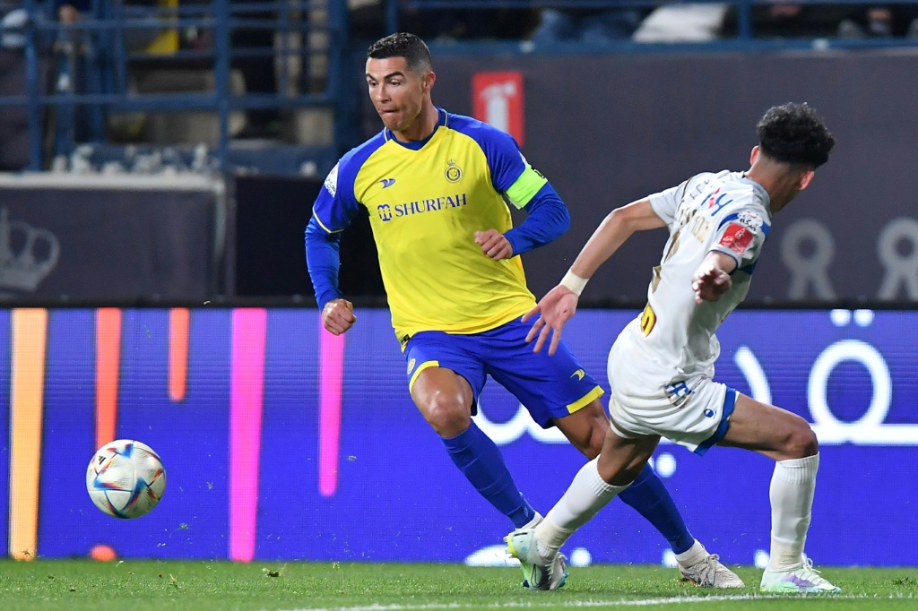 مهاجم النصر الدولي البرتغالي كريستيانو رونالدو يراوغ مدافع التعاون سعد الناصر في مباراة الفريقين في الدوري السعودي في 17 شباط/فبراير 2023 (ا ف ب)