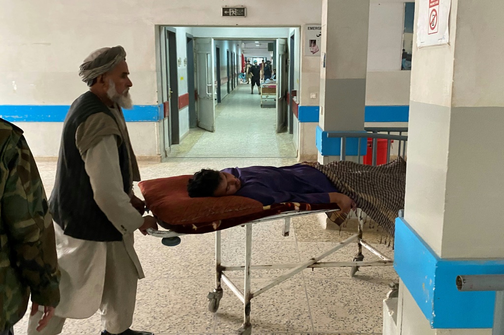    رجال ينقلون جريحاً داخل مستشفى في مزار الشريف بعد هجوم انتحاري على مكتب حاكم طالبان في ولاية بلخ الأفغانية. (أ ف ب)
