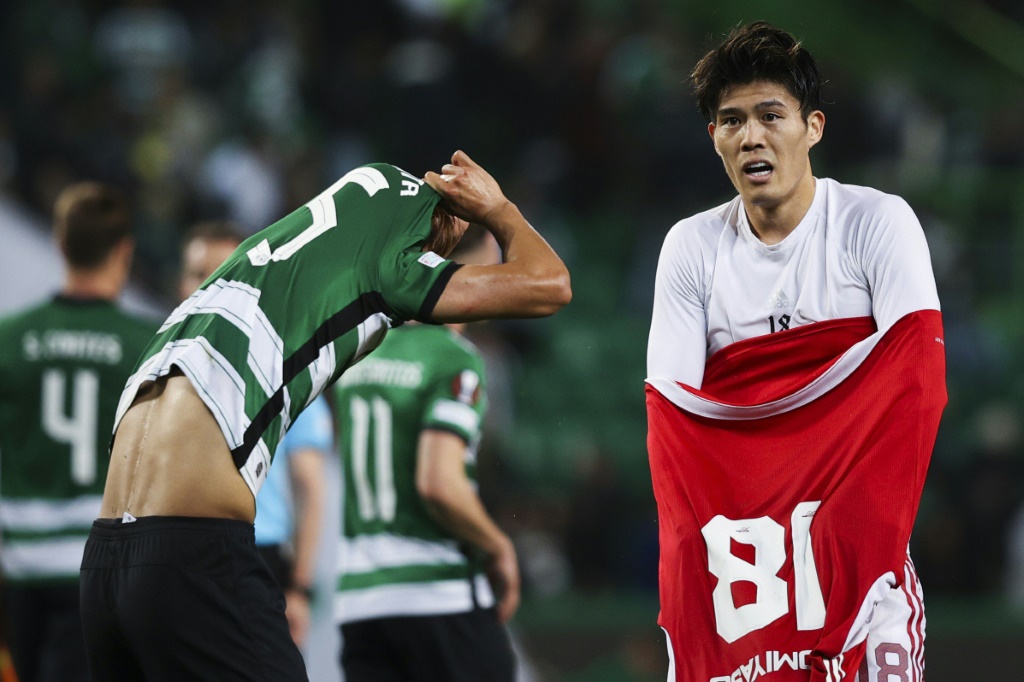 الياباني تاكيهيرو تومياسو (يمين) لاعب أرسنال الإنكليزي يبادل قميصه مع مواطنه لاعب سبورتينغ البرتغالي هيديماسا موريتا (ا ف ب)
