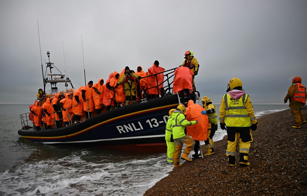     رجال إنقاذ بريطانيون يرافقون مهاجرين في 09 كانون الأول/ديسمبر 2022 (أ ف ب)