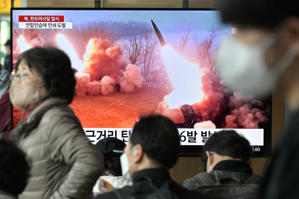 مارة يسيرون أمام شاشة تلفزيون تبث مشاهد لإطلاق صاروخين كوريين شماليين في إحدى محطات سيول في 14 آذار/مارس 2023 (ا ف ب)