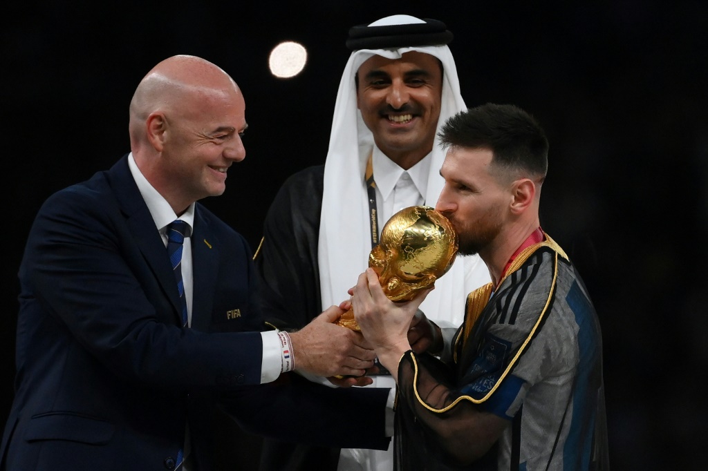&nbsp;إنفانتينو يسلم الأرجنتيني ليونيل ميسي كأس العالم 2022 في كرة القدم (ا ف ب)