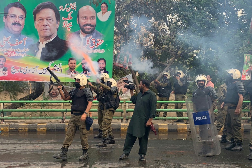 شرطة مكافحة الشغب تطلق قذائف الغاز المسيل للدموع لصد أنصار رئيس الوزراء السابق عمران خان تجمعوا خارج منزله لمنع اعتقاله. (ا ف ب)   