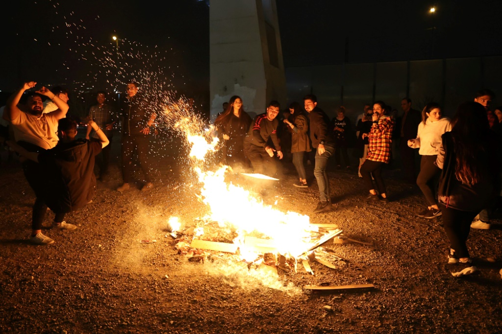    إيرانيون يرقصون حول نار خلال عيد النار الذي يقام سنويًا عشية الأربعاء الأخير قبل عطلة الربيع في طهران في 14 آذار/مارس 2023 (أ ف ب)   