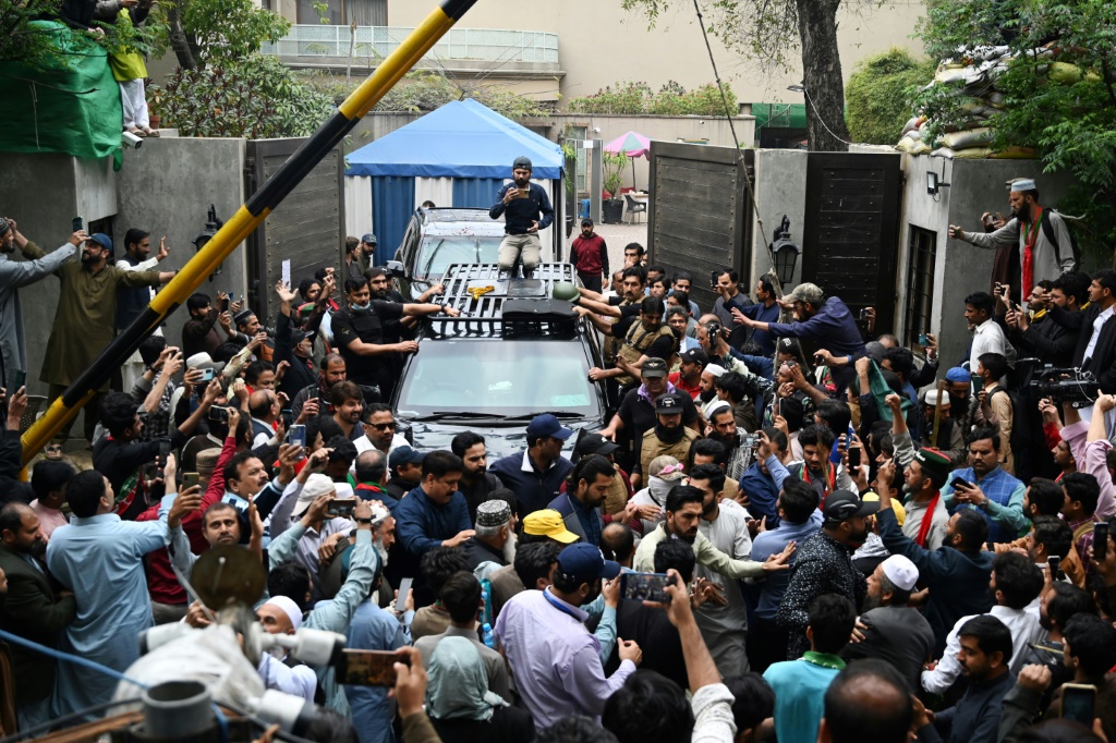    أنصار رئيس الوزراء الباكستاني السابق عمران خان يتجمعون حول سيارته بينما يغادر مقر إقامته في لاهور للمثول أمام المحكمة في إسلام أباد. (ا ف ب)