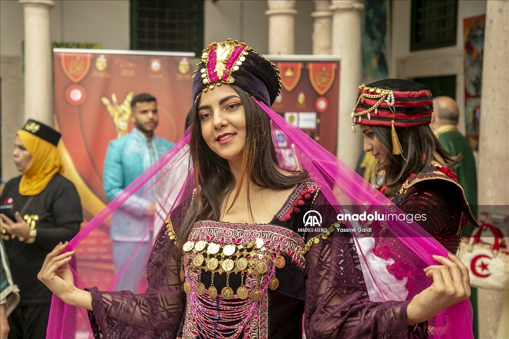 شارك في الاستعراض فتيات ونسوة لبسن ألبسة تقليدية تونسية مختلفة (الأناضول)