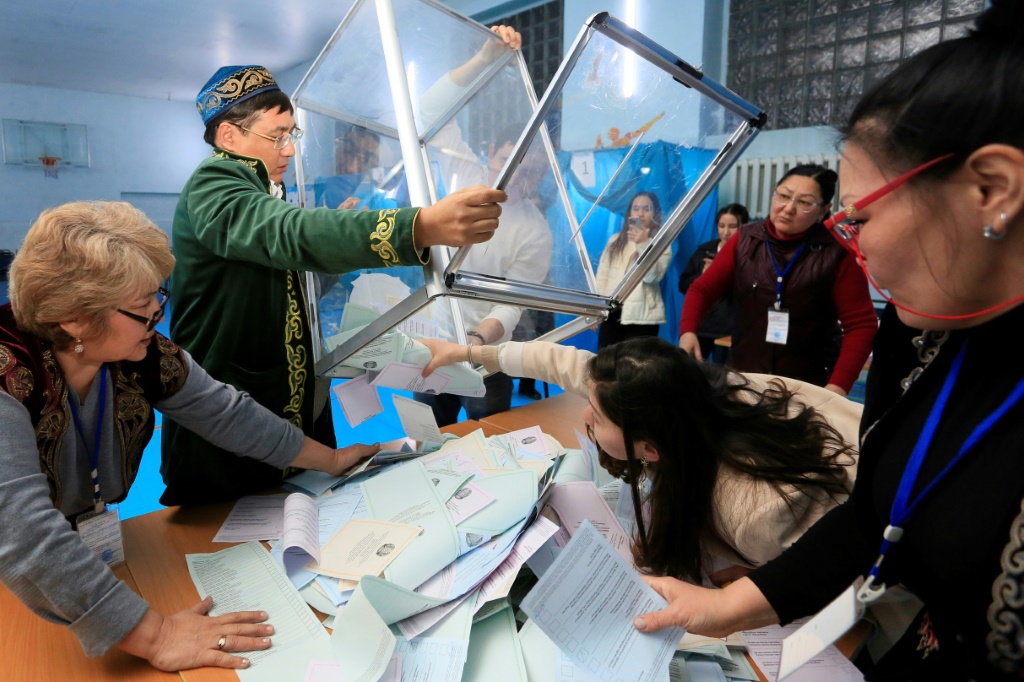  أعضاء لجنة انتخابية محلية يفرغون صندوق اقتراع في مركز اقتراع بعد الانتخابات البرلمانية في ألماتي (ا ف ب)