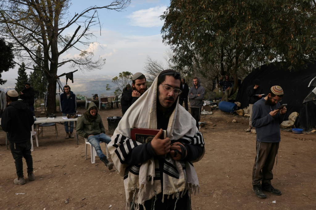 مستوطنون إسرائيليون من طلاب مدرسة حومش الدينية يؤدون الصلوات في موقع المستوطنة غرب مدينة نابلس في الضفة الغربية المحتلة في 30 كانون الأول/ديسمبر 2021 (ا ف ب)