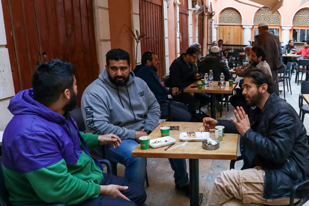 مجموعة من الرجال يشربون القهوة على شرفة في طرابلس عاصمة ليبيا في 16 آذار/مارس 2023 (ا ف ب)