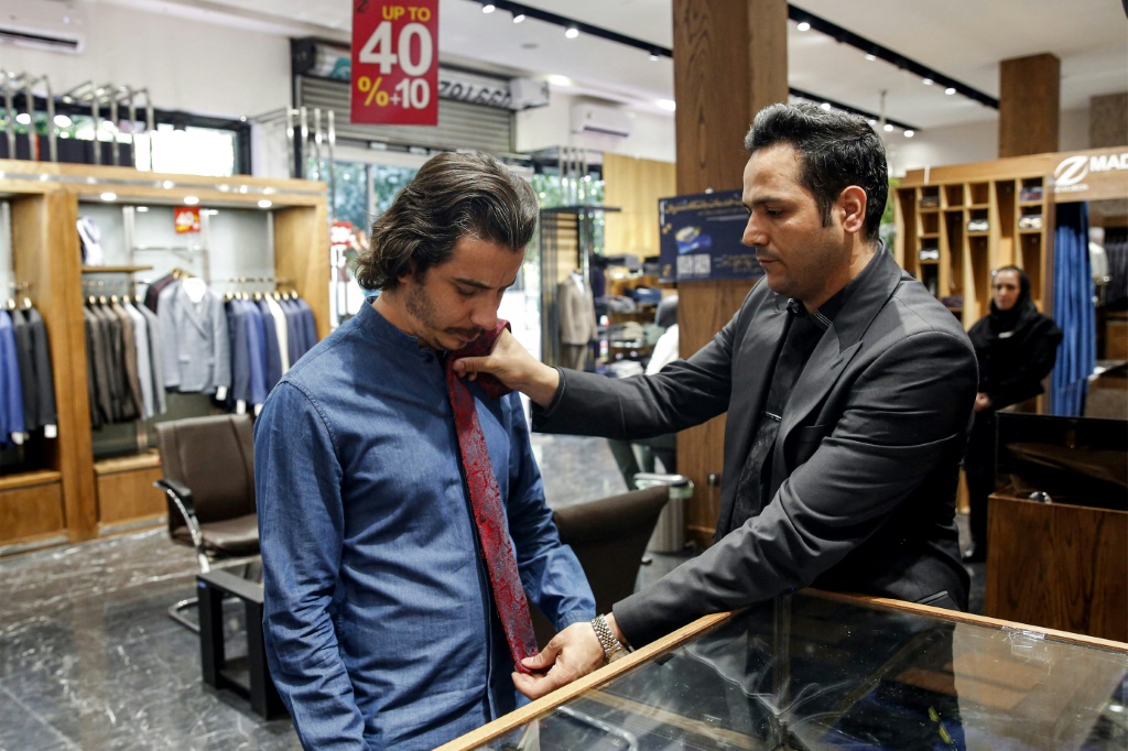 رجل يجرّب ربطات عنق في متجر للملابس في طهران في 7 أيلول/سبتمبر 2022 (ا ف ب)