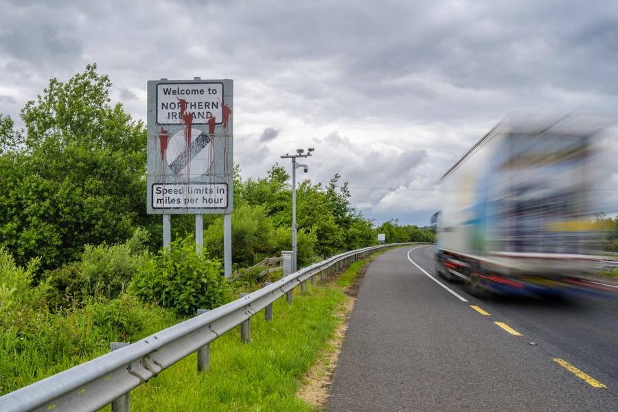 مركبة تمر بجانب لافتة حدودية بالقرب من نيوري، أيرلندا الشمالية، بريطانيا يوم 14 يونيو 2022 (شينخوا)