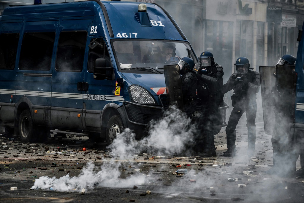 عناصر من الشرطة خلال إلقاء قنابل مسيلة للدموع في مدينة ليون في وسط فرنسا في 23 آذار/مارس 2023 خلال تظاهرات احتجاجا على إصلاح نظام التقاعد في فرنسا (ا ف ب)