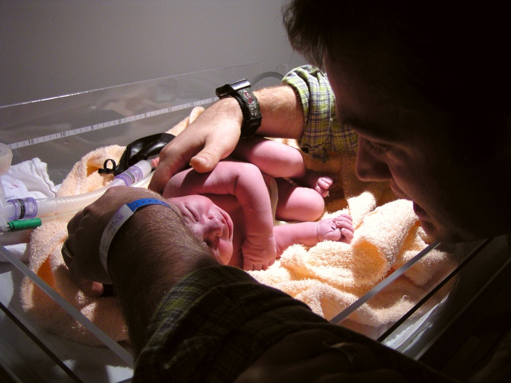 تعبيرية لطفل في حوض تدفئة بعد الولادة بحضور أبيه (ويكيبيديا)