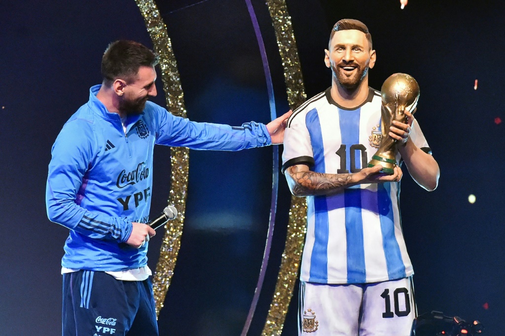 الأرجنتين ليونيل ميسي (يسار) الى جانب تمثال قدمه له اتحاد أميركا الجنوبية لكرة القدم في 27 آذار/مارس 2023 في الباراغواي (ا ف ب)