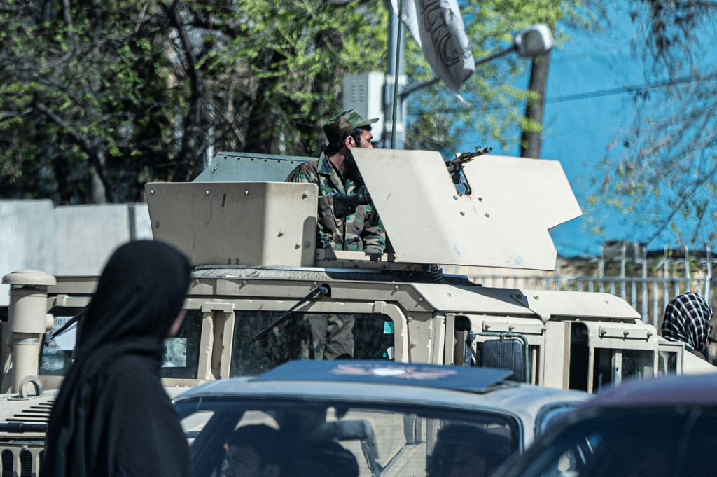     عنصر أمني من طالبان يجلس على عربة مدرعة من طراز همفي بالقرب من موقع هجوم انتحاري في كابول (أ ف ب)