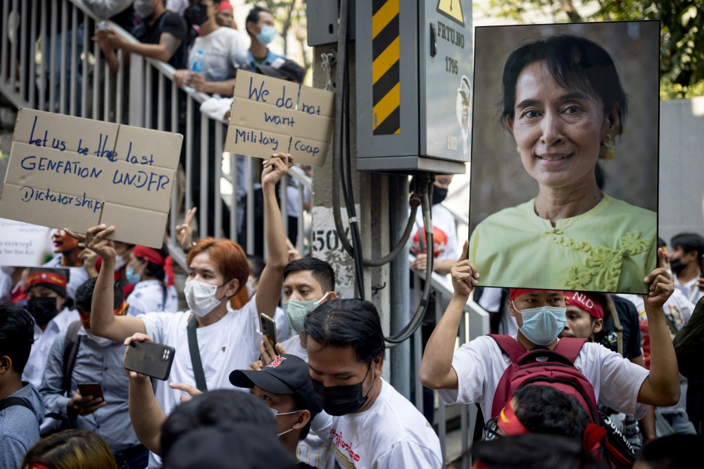 متظاهر يحمل صورة الحاكمة البورمية المسجونة أونغ سان سو تشي خلال تظاهرة خارج السفارة البورمية في بانكوك في الأول من شباط/فبراير 2023 في الذكرى الثاني للانقلاب العسكري (ا ف ب)