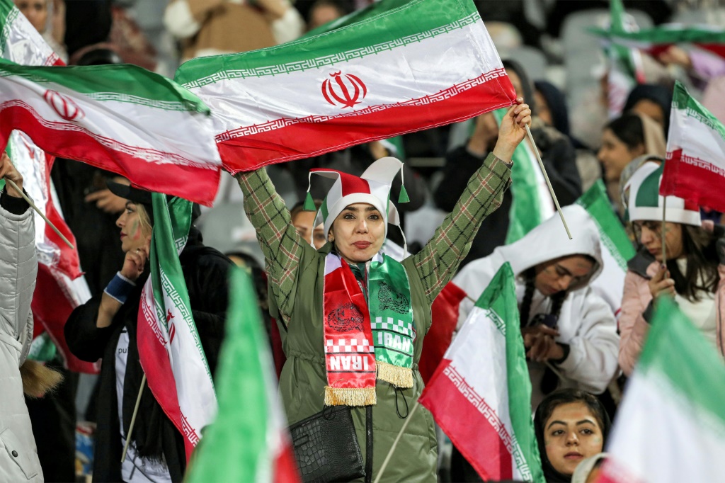 مشجّعات كرة قدم يحملن أعلامًا إيرانية خلال مباراة بين المنتخب الإيراني والمنتخب الروسي في طهران في 23 آذار/مارس 2023 (أ ف ب)