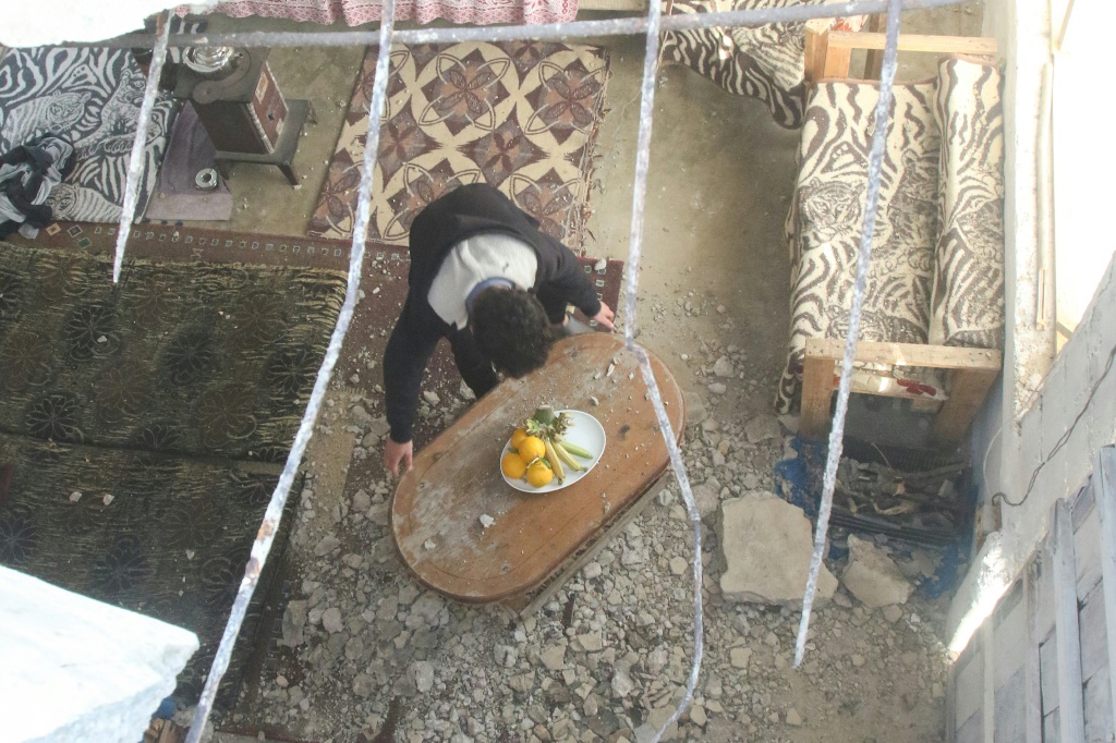 رجل يعمل على رفع الأضرار داخل منزله على أطراف بلدة القليلة في جنوب لبنان في 7 نيسان/أبريل 2023 بعد سقوط صاروخ اسرائيلي على السطح في إطار غارات نفذتها إسرائيل فجراً رداً على وابل من الصواريخ أُطلق من المنطقة ذاتها باتجاهها (ا ف ب)