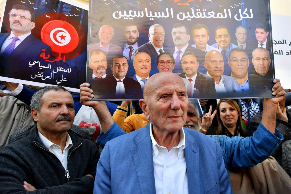  المتظاهرون التونسيون ومنهم أحمد نجيب الشابي رئيس ائتلاف جبهة الإنقاذ الوطني رفعوا لافتات عليها صور المعتقلين. (ا ف ب)