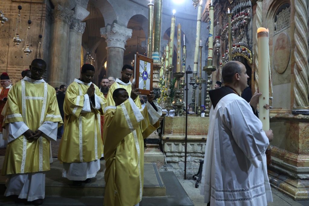 رجال دين مسيحيون يشاركون في قداس عيد الفصح في كنيسة القيامة في القدس الشرقية المحتلة في التاسع من نيسان/أبريل 2023 (ا ف ب)