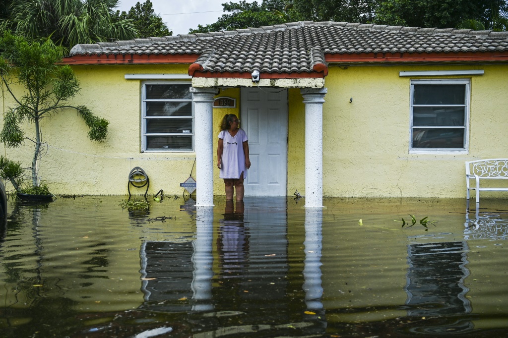     امرأة تقف أمام منزلها وسط فيضان بعد أمطار غزيرة في فورت لودرديل بولاية فلوريدا الأميركية في 13 نيسان/أبريل 2023 (ا ف ب)