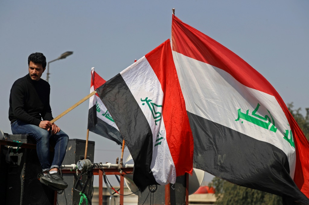 متظاهرون يرفعون العلم العراقي في بغداد في 27 شباط/فبراير 2023 (ا ف ب)