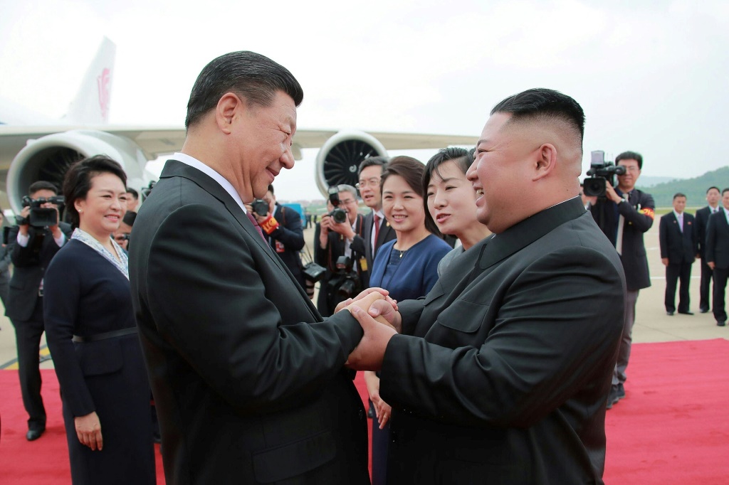 الزعيم الكوري الشمالي كيم يونغ أون يصافح الرئيس الصيني شي جينبينغ لدى وصوله الى مطار بيونغ يانغ في 20 حزيران/يونيو 2019 (ا ف ب)