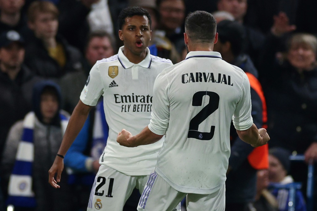 مهاجم ريال مدريد الاسباني الدولي البرازيلي رودريغو يحتفل مع زميله داني كارفاخال بهز شباك تشلسي الانكليزي في اياب ربع نهائي مسابقة دوري ابطال اوروبا في لندن في 18 نيسان/أبريل 2023. (ا ف ب)