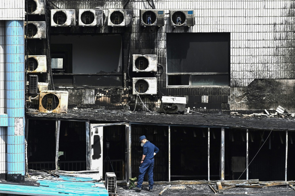 أحد عناصر التحقيق يتفقد آثار الحريق الدامي في أحد مستشفيات بكين في 19 نيسان/أبريل 2023 (ا ف ب)