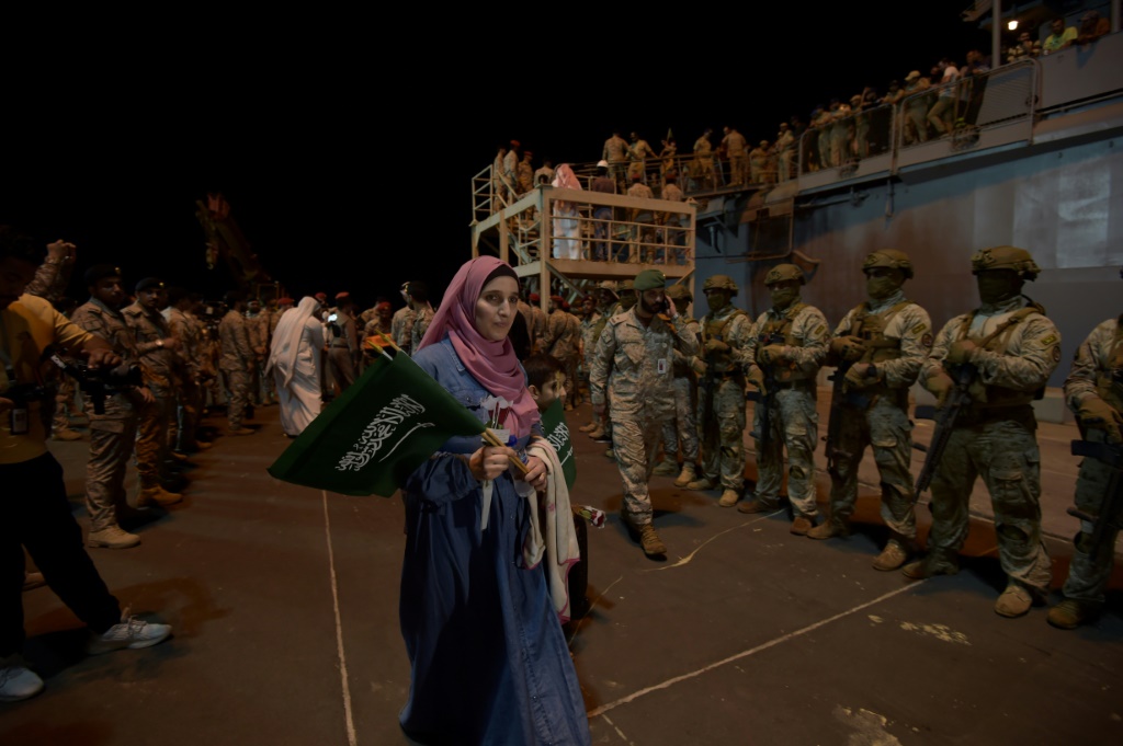    سعوديون ورعايا من دول أخرى تمّ إجلاؤهم من السودان ينزلون من السفينة إثر وصولهم إلى قاعدة الملك فيصل البحرية في جدة في 24 نيسان/أبريل 2023 (ا ف ب)