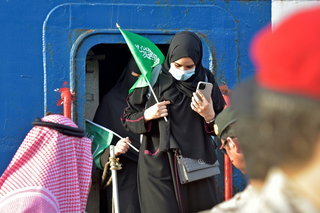  أفراد البحرية السعودية يساعدون المدنيين على الخروج من سفينة الإجلاء بعد أن رست في قاعدة الملك فيصل في جدة (أ ف ب)