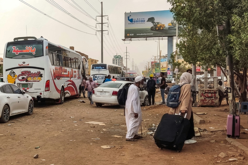 مدنيون سودانيون يستعدون للفرار من القتال في العاصمة الخرطوم يستعدون للصعود إلى الحافلة (ا ف ب)