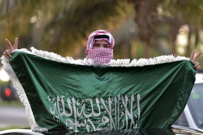 شاب يرفع العلم السعودي (أ ف ب)