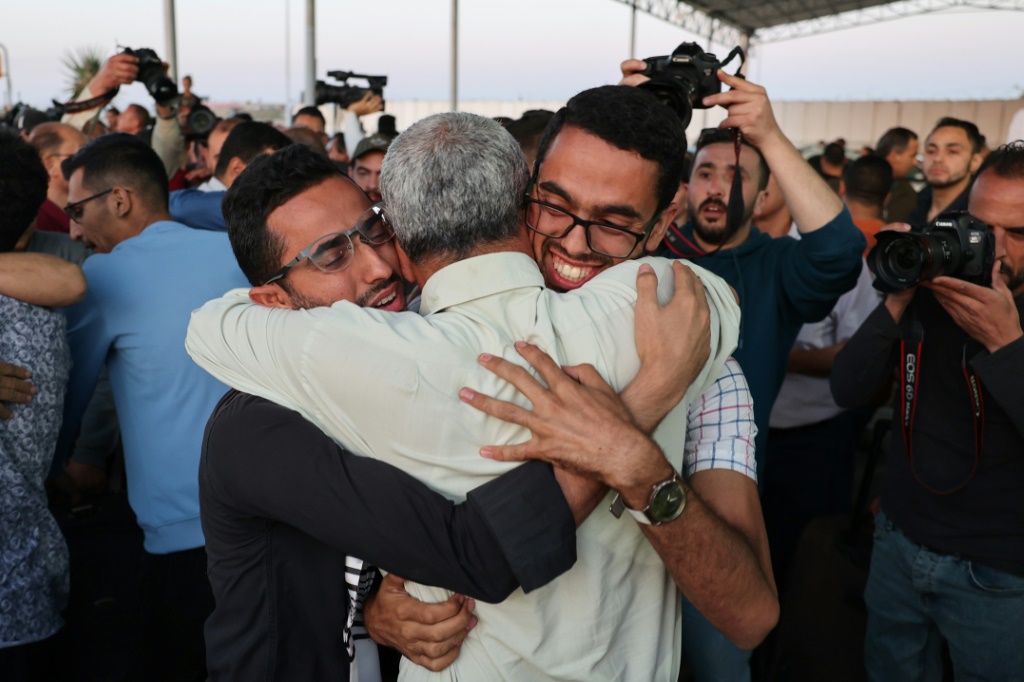    الأقارب يرحبون بالفلسطينيين الذين تم إجلاؤهم من السودان عند وصولهم إلى قطاع غزة عبر معبر رفح الحدودي مع مصر (أ ف ب)
