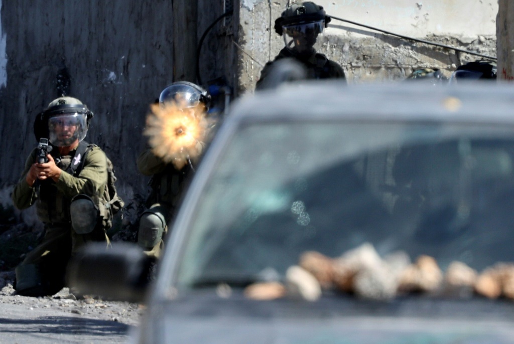 تداول ناشطون وإعلاميون صورا للفلسطينييْن وآثار الدماء الغزير على ملابس المصابين ووجهيهما (أ ف ب)