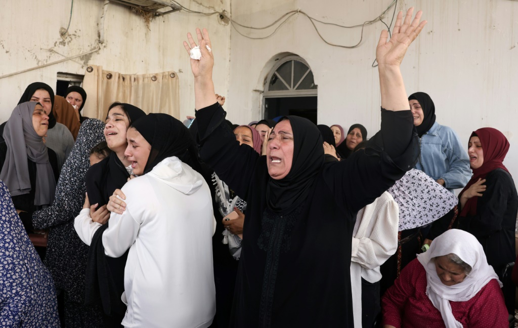 أفراد عائلة الفتى الفلسطيني محمد فايز بلهان (15 عاما) خلال وداعهم لجثمانه إثر مقتله برصاص الجيش الإسرائيلي في مخيم عقبة جبر قرب مدينة أريحا في الضفة الغربية المحتلة في 10 نيسان/أبريل 2023 (أ ف ب)