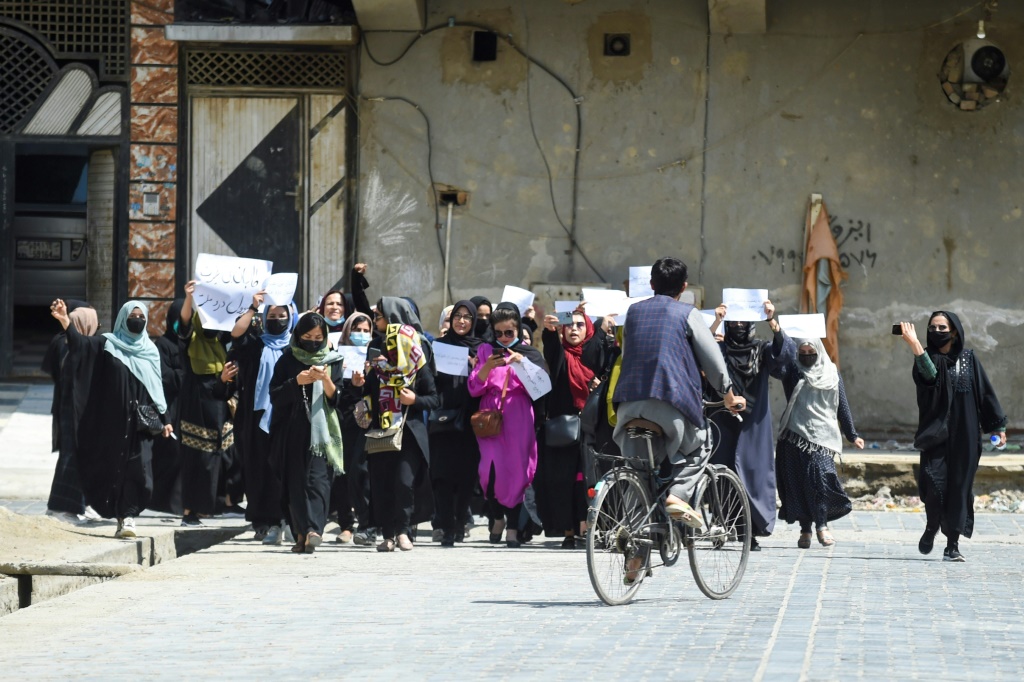  أفغانيات يحملنَ لافتات أثناء تظاهرة في كابول في 29 نيسان/أبريل 2023 احتجاجًا على احتمال اعتراف دولي بسلطات طالبان (أ ف ب)