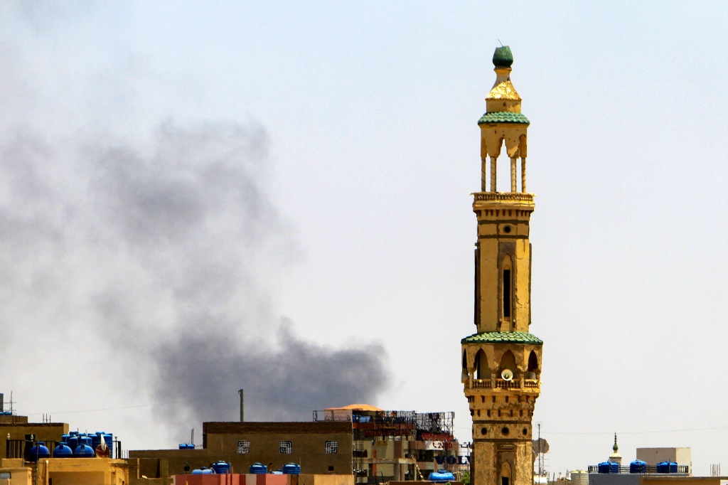    دخان يتصاعد فوق مبان خلف مسجد أثناء القتال في الخرطوم (أ ف ب)