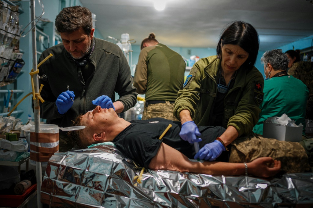 مسعفون يقدمون الإسعافات الأولية لجندي أوكراني مصاب في مركز طبي بالقرب من مدينة باخموت في منطقة دونيتسك، في 4 أيار/مايو 2023 (ا ف ب)