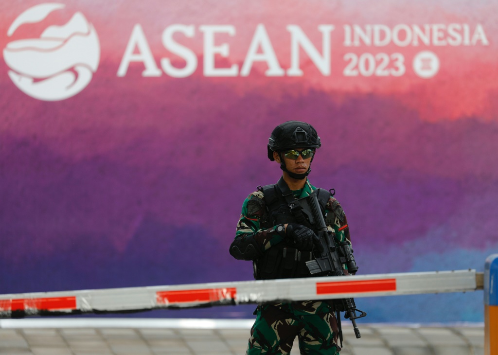 صورة مؤرخة في 9 أيار/مايو 2023 لجندي إندونيسي أمام شعار قمة "آسيان" في لابوان باجو (ا ف ب)