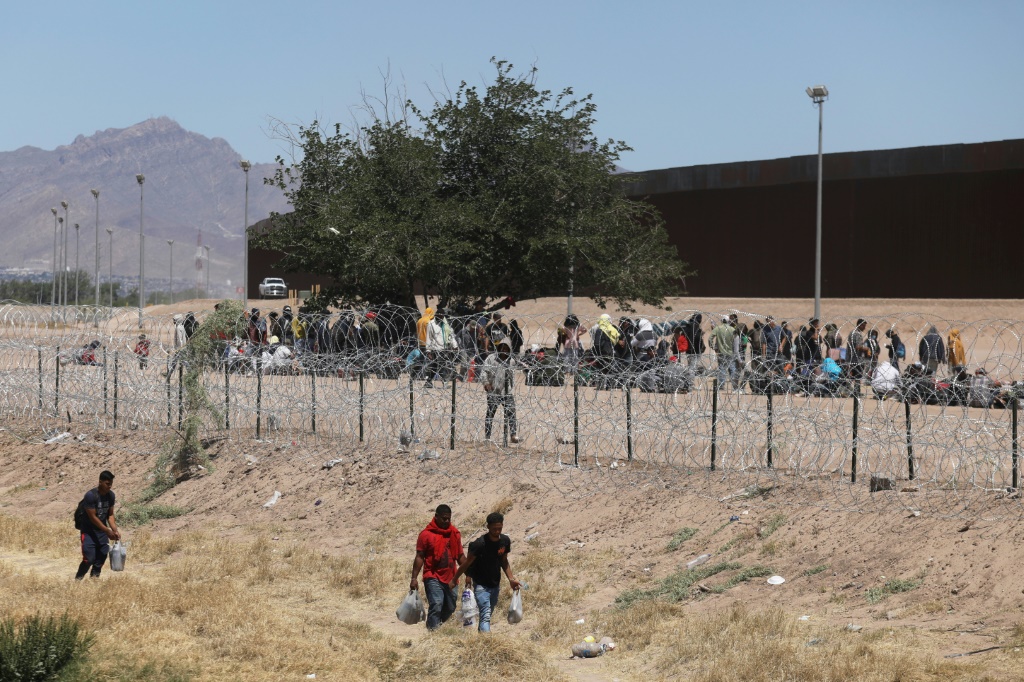 مهاجريون ينتظرون على ضفة نهر ريو غراندي على الحدود بين المكسيك والولايات المتحدة في 8 أيار/مايو 2023 في سيوداد خواريز. (ا ف ب)