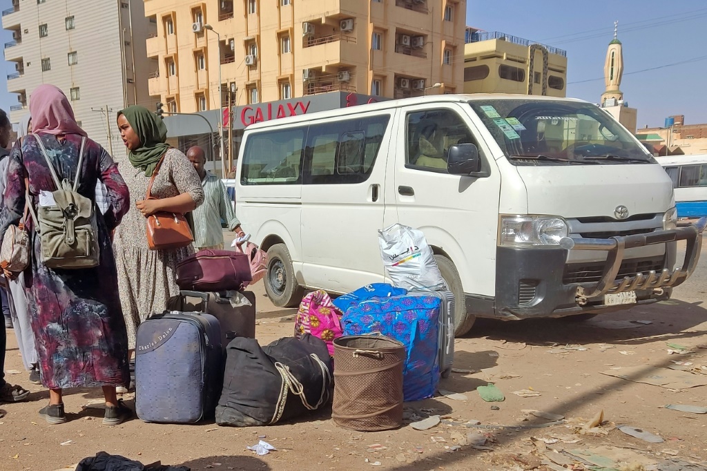 سودانيون ينتظرون مع حقائبهم في محطة حافلات في جنوب الخرطوم في الثامن من ايار/مايو 2023 مع تواصل القتال بين الجيش وقوات الدعم السريع (ا ف ب)