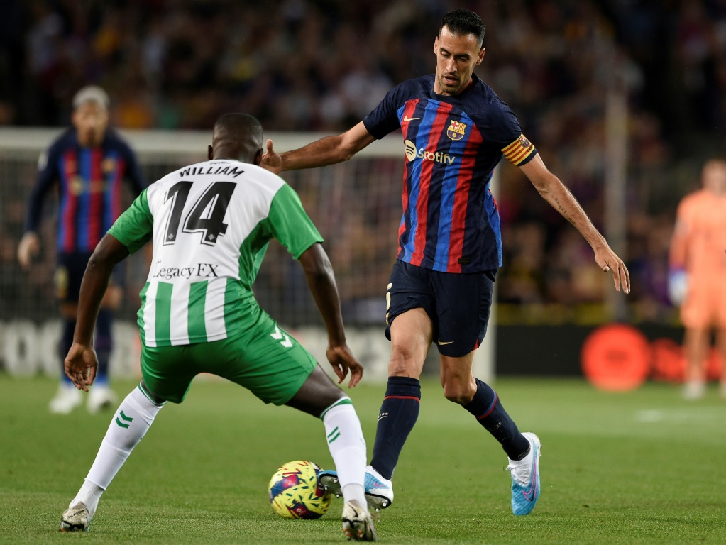 قائد برشلونة سيرجيو بوسكيتس (يمين) يحاول مراوغة لاعب وسط ريال بيتيس البرتغالي وليام كارفاليو خلال مباراة الفريقين في الدوري الاسباني في برشلونة في 29* نيسان/أبريل 2023. (ا ف ب)