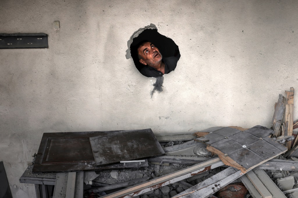 فلسطيني يتفقد منزله الذي أصيب في قصف سرائيلي في قطاع غزة في 13 أيار/مايو 2023 (ا ف ب)