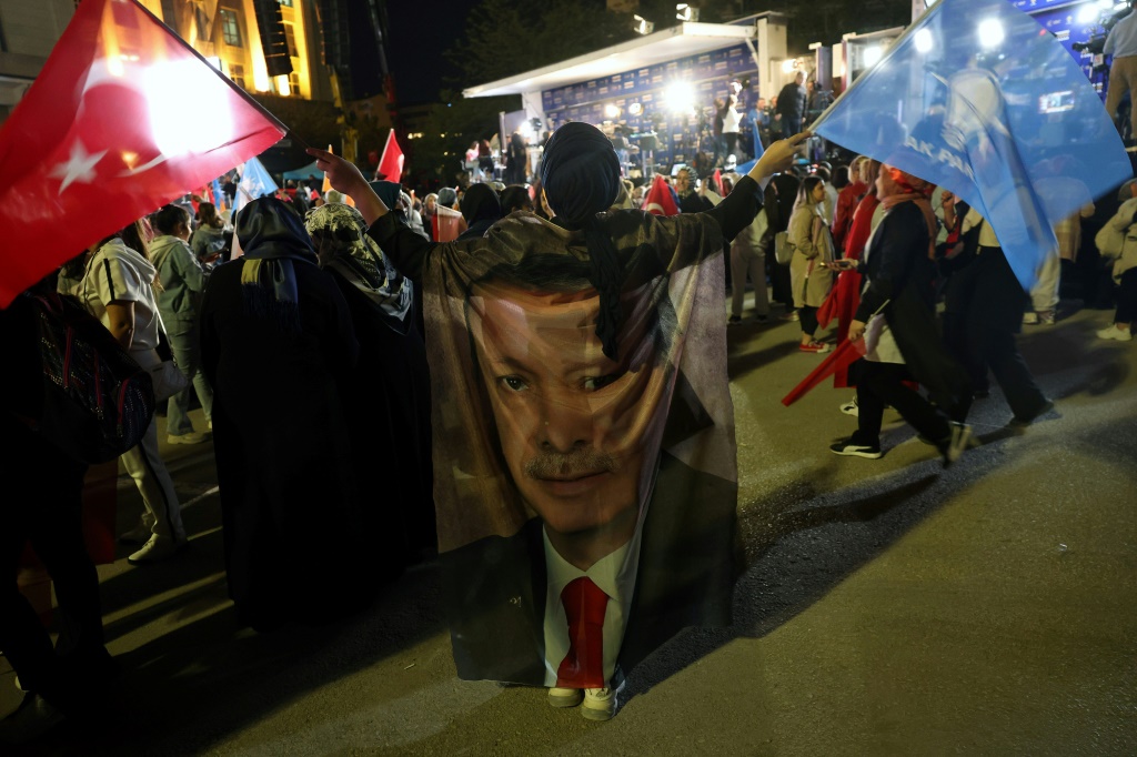      أنصار الرئيس التركي رجب طيب أردوغان يلوّحون بالأعلام خارج مقر حزب العدالة والتنمية بعد إغلاق مراكز الاقتراع في الانتخابات الرئاسية والبرلمانية التركية في أنقرة، تركيا، 15 أيار/مايو 2023(أ ف ب)