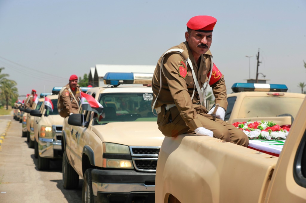     مركبات عسكرية عراقية في بغداد بتاريخ 16 أيار/مايو 2023 تنقل توابيت تضم رفات أخاص قتلوا بأيدي تنظيم الدولة الإسلامية وعثر على رفاتهم في مقابر جماعية عام 2017 (أ ف ب)   