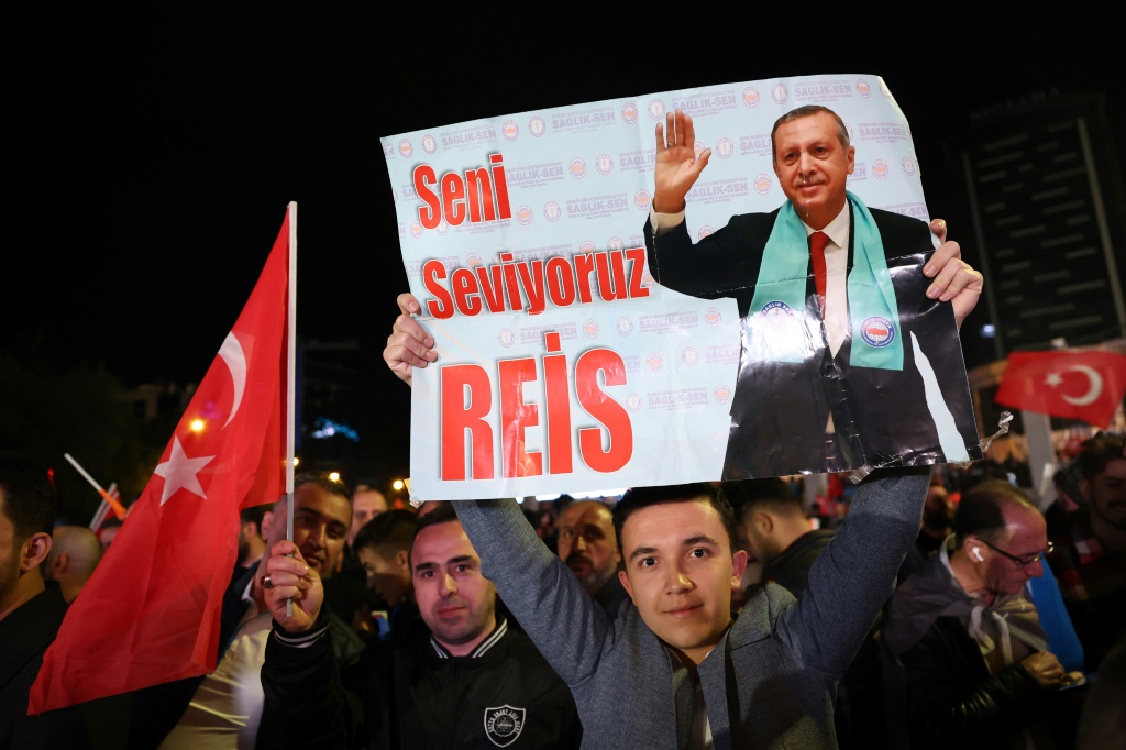 مؤيد للرئيس التركي رجب طيب اردوغان يحمل لافتة كتب عليها "نحن نحبك ايها الريس" امام مقر حزب العدالة والتنمية في انقرة في 15 ايار/مايو 2023 (ا ف ب)
